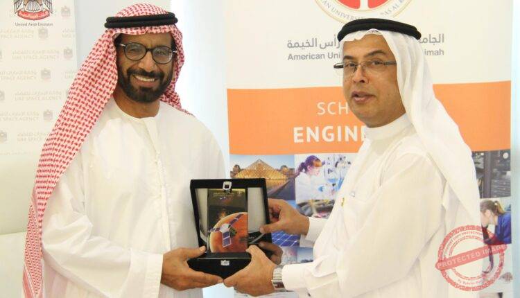 Professor Al Alkim and H. E. Dr. Al Romaithi exchange tokens of appreciation following the signing of the memorandum of understanding